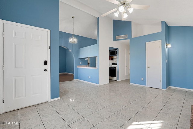 unfurnished living room with light tile patterned floors, ceiling fan with notable chandelier, high vaulted ceiling, and sink