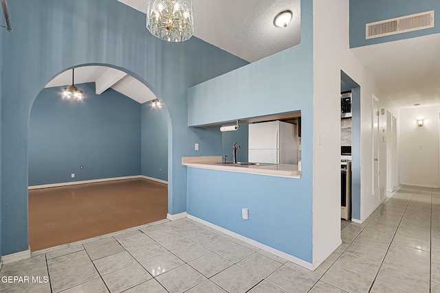 unfurnished living room featuring sink, a chandelier, high vaulted ceiling, light tile patterned floors, and beam ceiling