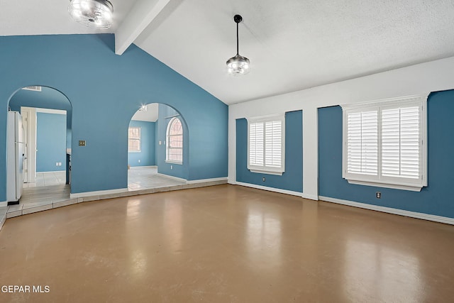 spare room with vaulted ceiling with beams, concrete floors, and a textured ceiling