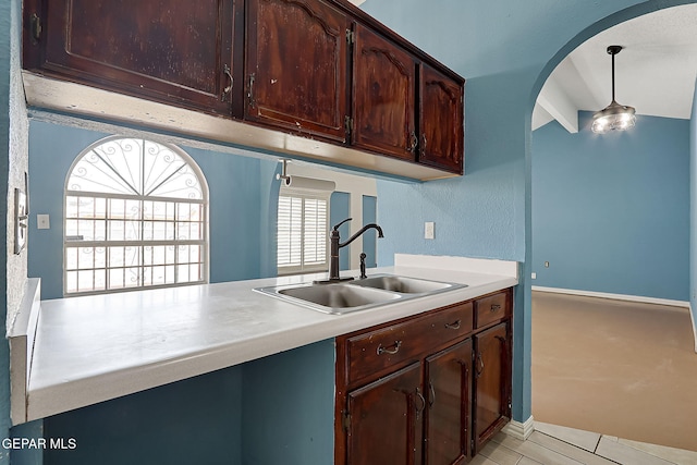 kitchen with pendant lighting, kitchen peninsula, and sink