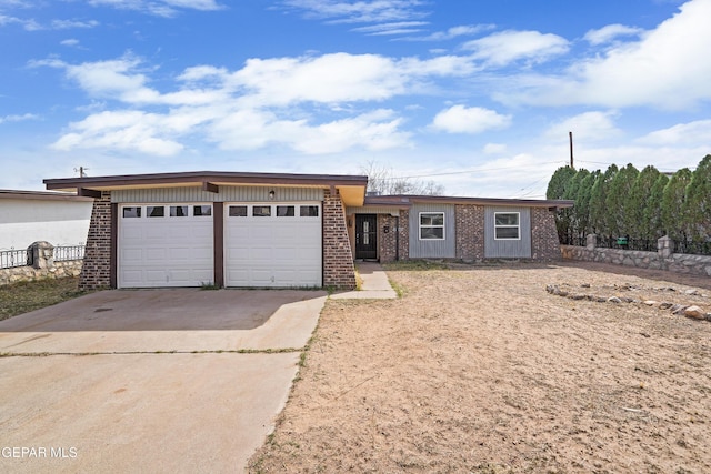 single story home featuring a garage, driveway, and brick siding