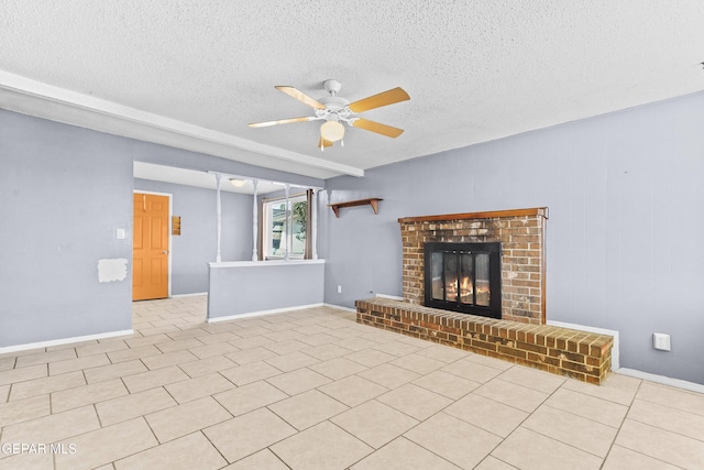 unfurnished living room featuring a fireplace, light tile patterned floors, a ceiling fan, a textured ceiling, and baseboards