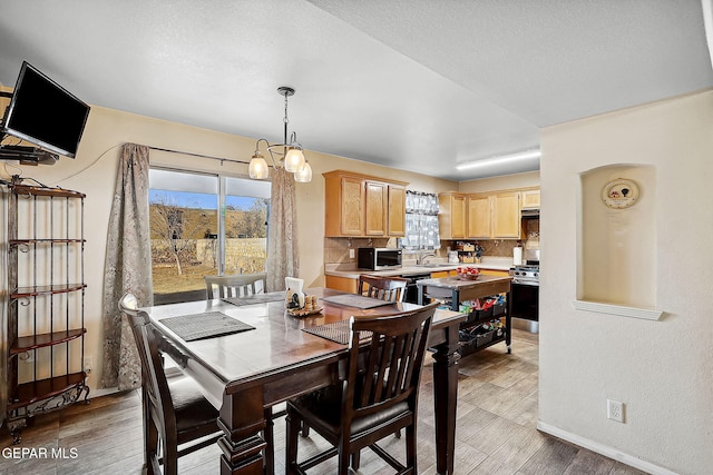 dining room featuring hardwood / wood-style flooring, plenty of natural light, and sink