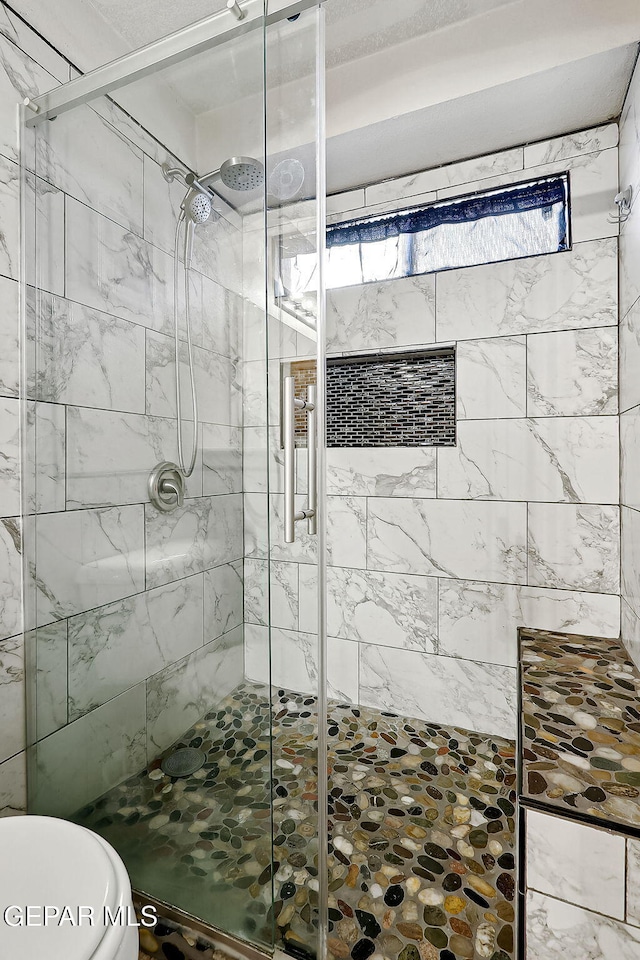 bathroom with an enclosed shower and toilet