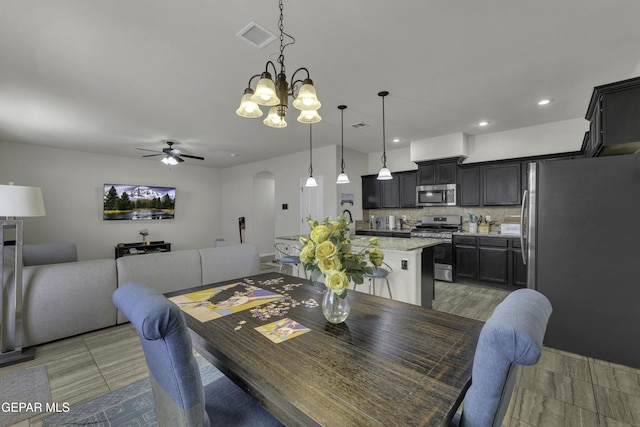 dining area with ceiling fan with notable chandelier