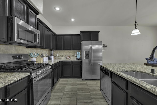 kitchen with sink, hanging light fixtures, stainless steel appliances, light stone countertops, and decorative backsplash