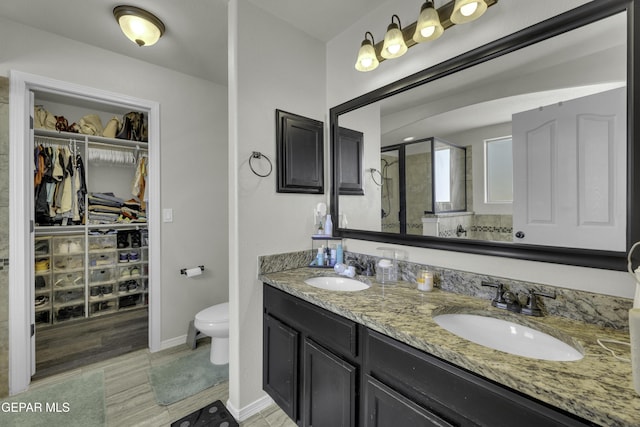 bathroom featuring walk in shower, vanity, and toilet