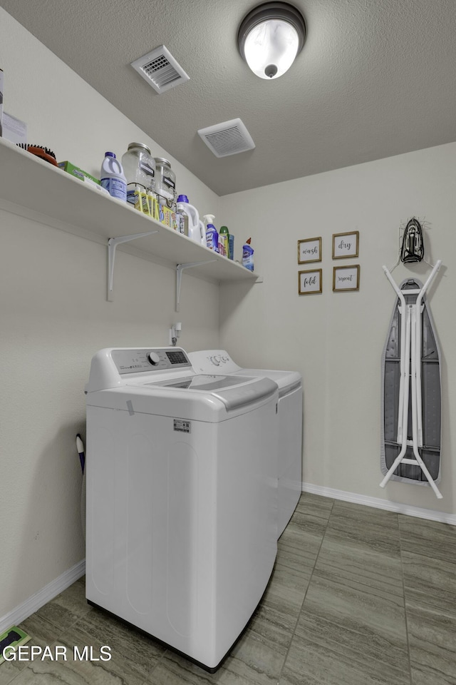 laundry room featuring washer and dryer and a textured ceiling