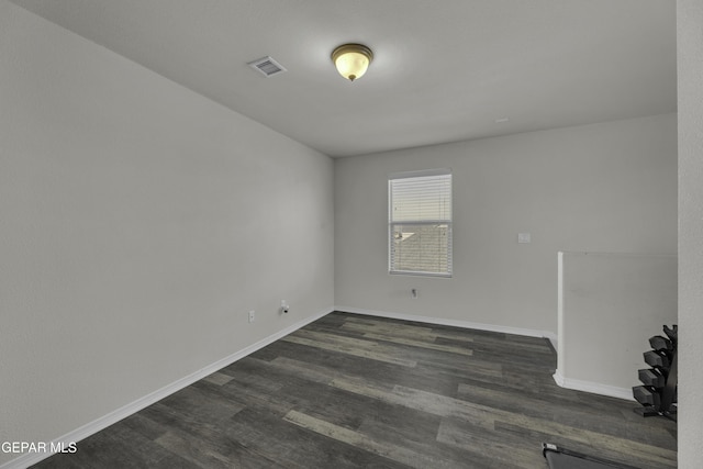 empty room with dark hardwood / wood-style flooring