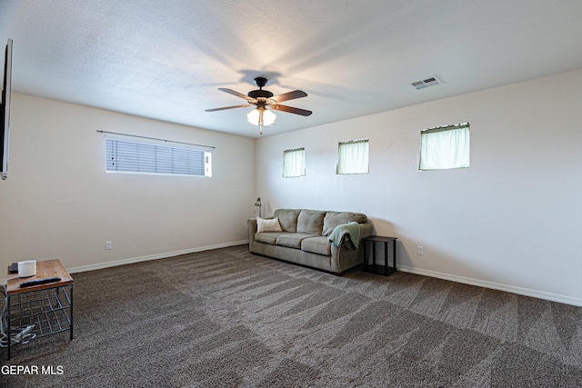 unfurnished living room featuring dark colored carpet, a textured ceiling, and ceiling fan