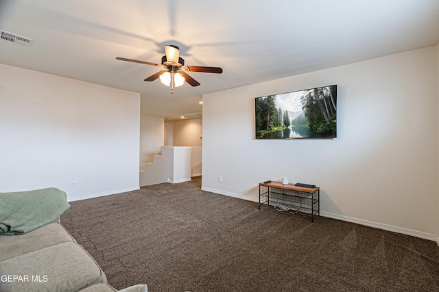 living room featuring dark colored carpet and ceiling fan