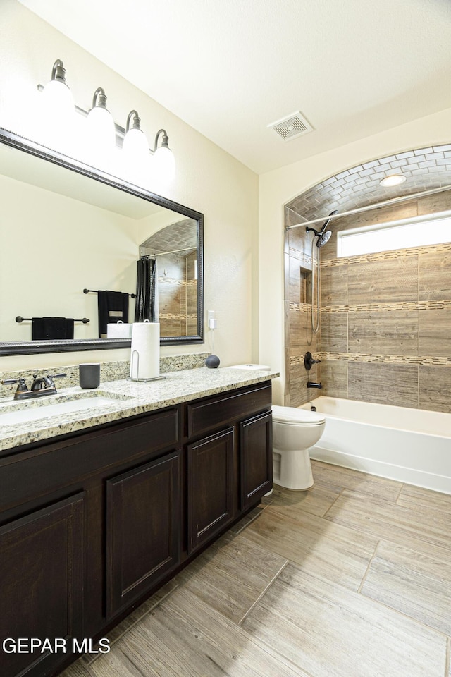 full bathroom with vanity, shower / tub combo with curtain, and toilet