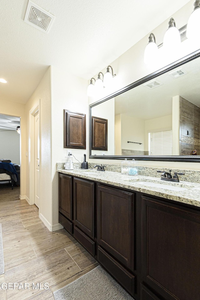 bathroom featuring vanity, hardwood / wood-style floors, and a textured ceiling