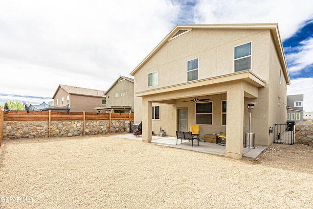 rear view of property with a patio and ceiling fan