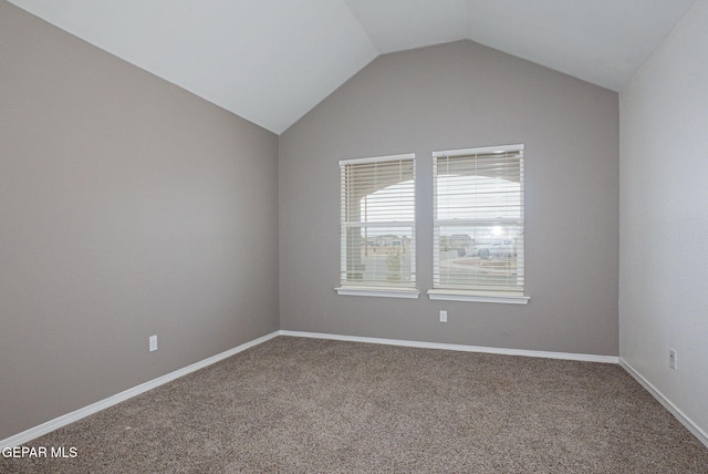 spare room featuring vaulted ceiling and carpet