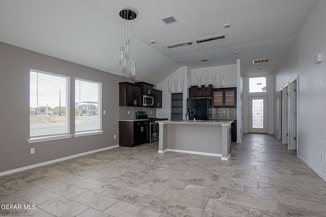 kitchen featuring dark brown cabinets, stainless steel appliances, decorative backsplash, a center island with sink, and decorative light fixtures