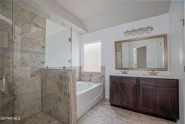 bathroom with vanity, vaulted ceiling, and independent shower and bath