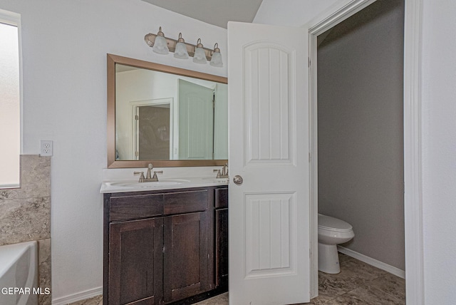 bathroom with vanity, a bathing tub, and toilet