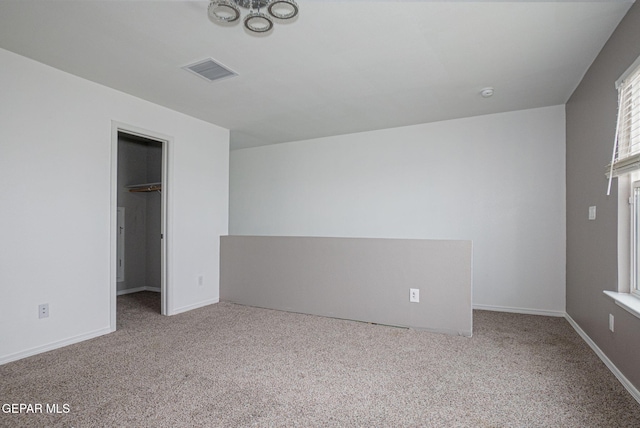 unfurnished bedroom with a spacious closet and light carpet