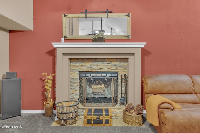 living area with a stone fireplace and carpet flooring