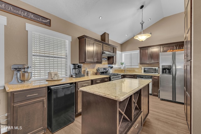 kitchen with a center island, dark brown cabinets, hanging light fixtures, light hardwood / wood-style flooring, and appliances with stainless steel finishes