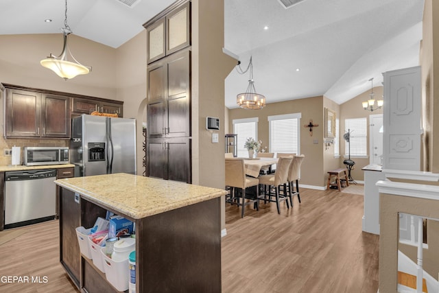 kitchen featuring pendant lighting, light hardwood / wood-style flooring, appliances with stainless steel finishes, dark brown cabinets, and a kitchen island