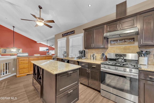 kitchen featuring vaulted ceiling, dark brown cabinetry, gas stove, light stone countertops, and light hardwood / wood-style flooring