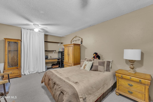 bedroom featuring ceiling fan, light carpet, and a textured ceiling