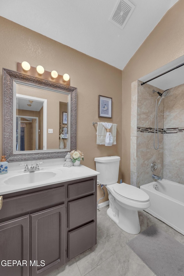 full bathroom with tiled shower / bath, vanity, toilet, and lofted ceiling