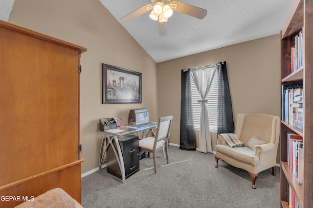 carpeted office with ceiling fan, vaulted ceiling, and a textured ceiling