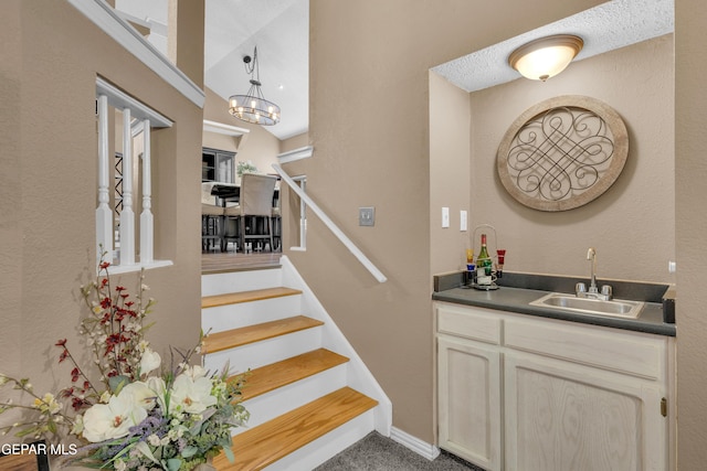 stairs featuring carpet floors and sink