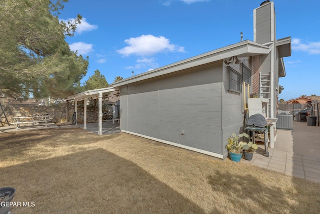 view of property exterior with a yard and a patio area