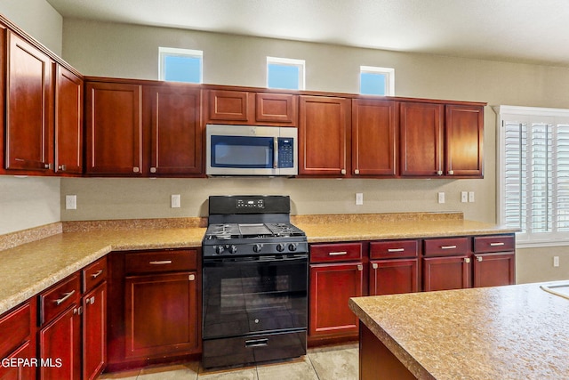 kitchen featuring gas stove and light tile patterned flooring