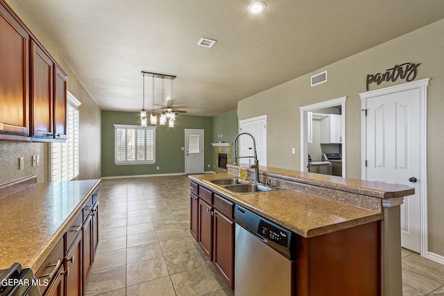 kitchen with washer and dryer, pendant lighting, an island with sink, dishwasher, and sink