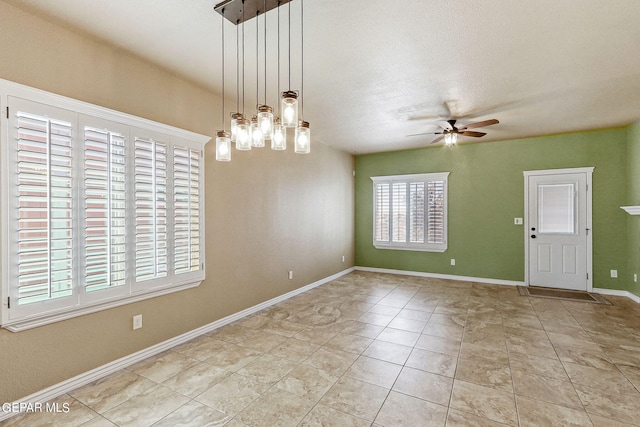 interior space featuring ceiling fan with notable chandelier, a textured ceiling, and light tile patterned floors