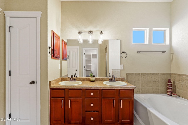 bathroom featuring vanity and a washtub