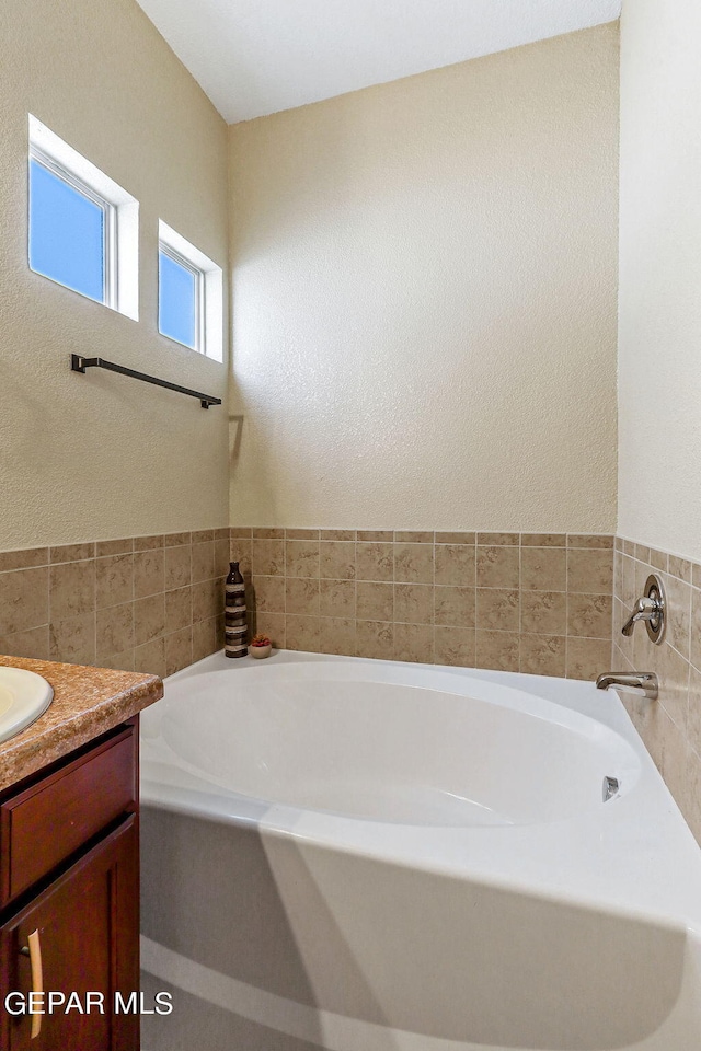 bathroom with vanity and a bath