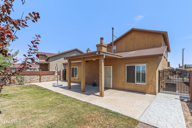 back of property with a yard and a patio area