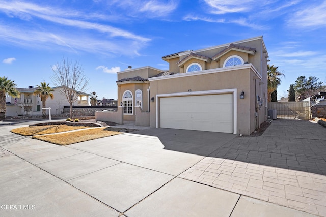 mediterranean / spanish-style home featuring a garage and central air condition unit