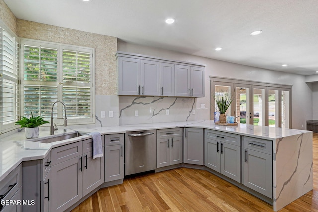 909 Singing Hills Dr, El Paso, TX 79912 - kitchen with gray cabinetry, stainless steel dishwasher, a peninsula, a sink, and light wood-type flooring
