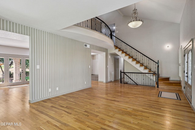 909 Singing Hills Dr, El Paso, TX 79912 - unfurnished living room with french doors, wood finished floors, stairway, high vaulted ceiling, and baseboards