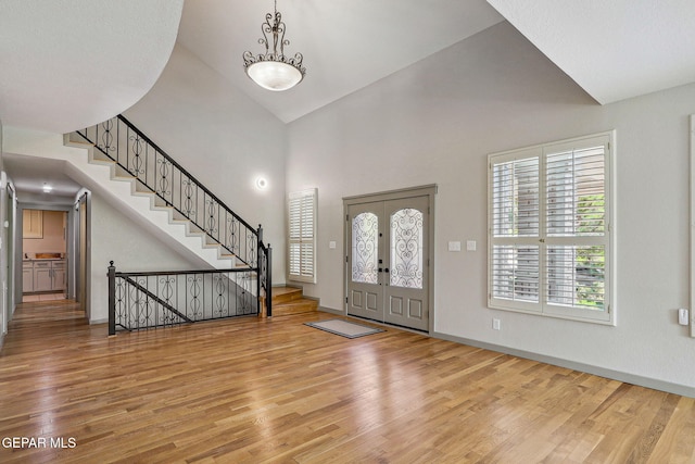 909 Singing Hills Dr, El Paso, TX 79912 - entrance foyer featuring wood finished floors, high vaulted ceiling, stairway, and baseboards