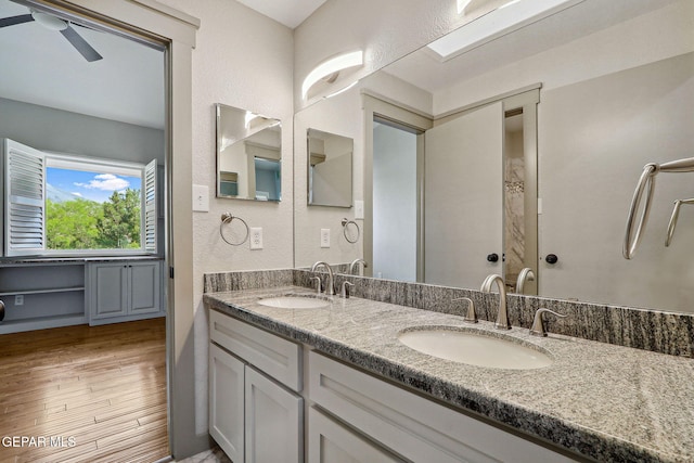 909 Singing Hills Dr, El Paso, TX 79912 - full bath featuring wood finished floors, double vanity, a ceiling fan, and a textured wall