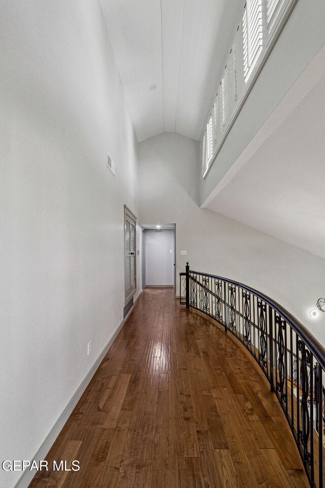 909 Singing Hills Dr, El Paso, TX 79912 - corridor featuring hardwood / wood-style flooring, high vaulted ceiling, baseboards, and an upstairs landing
