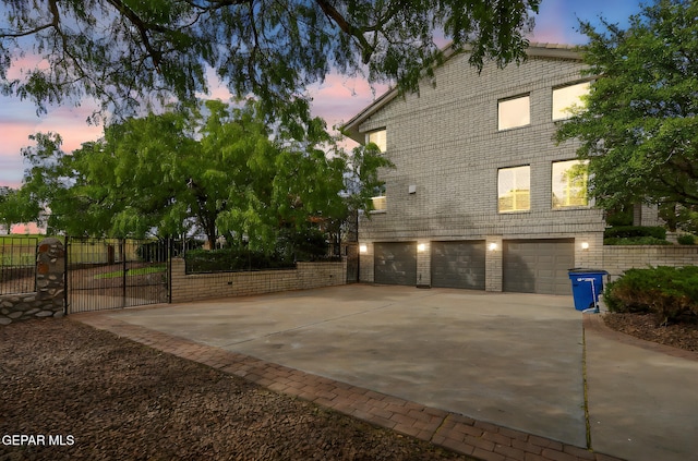 909 Singing Hills Dr, El Paso, TX 79912 - view of property exterior featuring an attached garage, driveway, a gate, fence, and brick siding