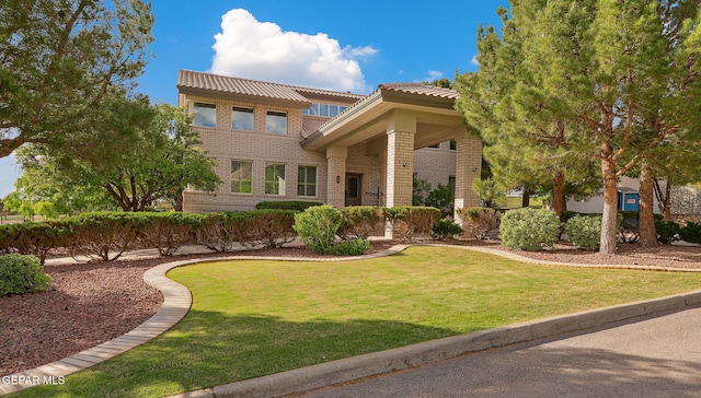 909 Singing Hills Dr, El Paso, TX 79912 - view of front of home featuring brick siding, a tile roof, and a front lawn