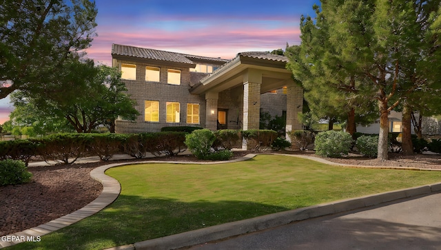909 Singing Hills Dr, El Paso, TX 79912 - view of front of property with a tile roof, a lawn, and brick siding