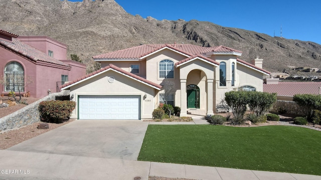 mediterranean / spanish-style home with a tiled roof, a front yard, driveway, and stucco siding