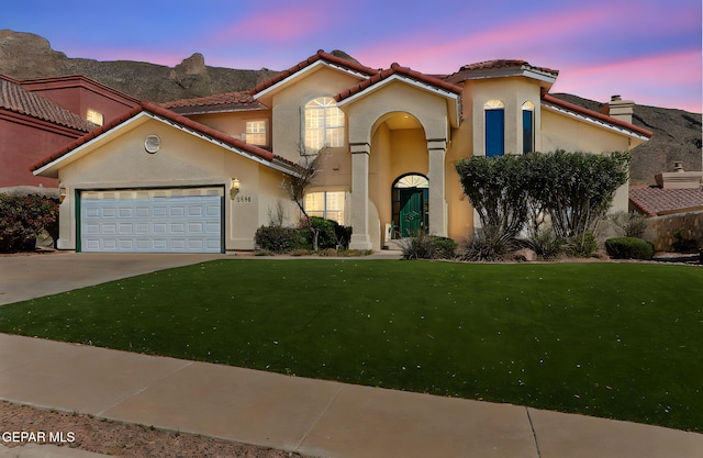 mediterranean / spanish-style house featuring an attached garage, a tiled roof, concrete driveway, and a front yard