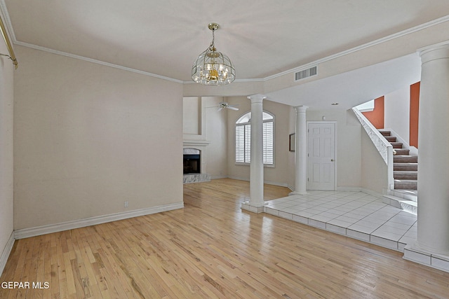 unfurnished living room featuring ornate columns, ornamental molding, visible vents, and hardwood / wood-style floors